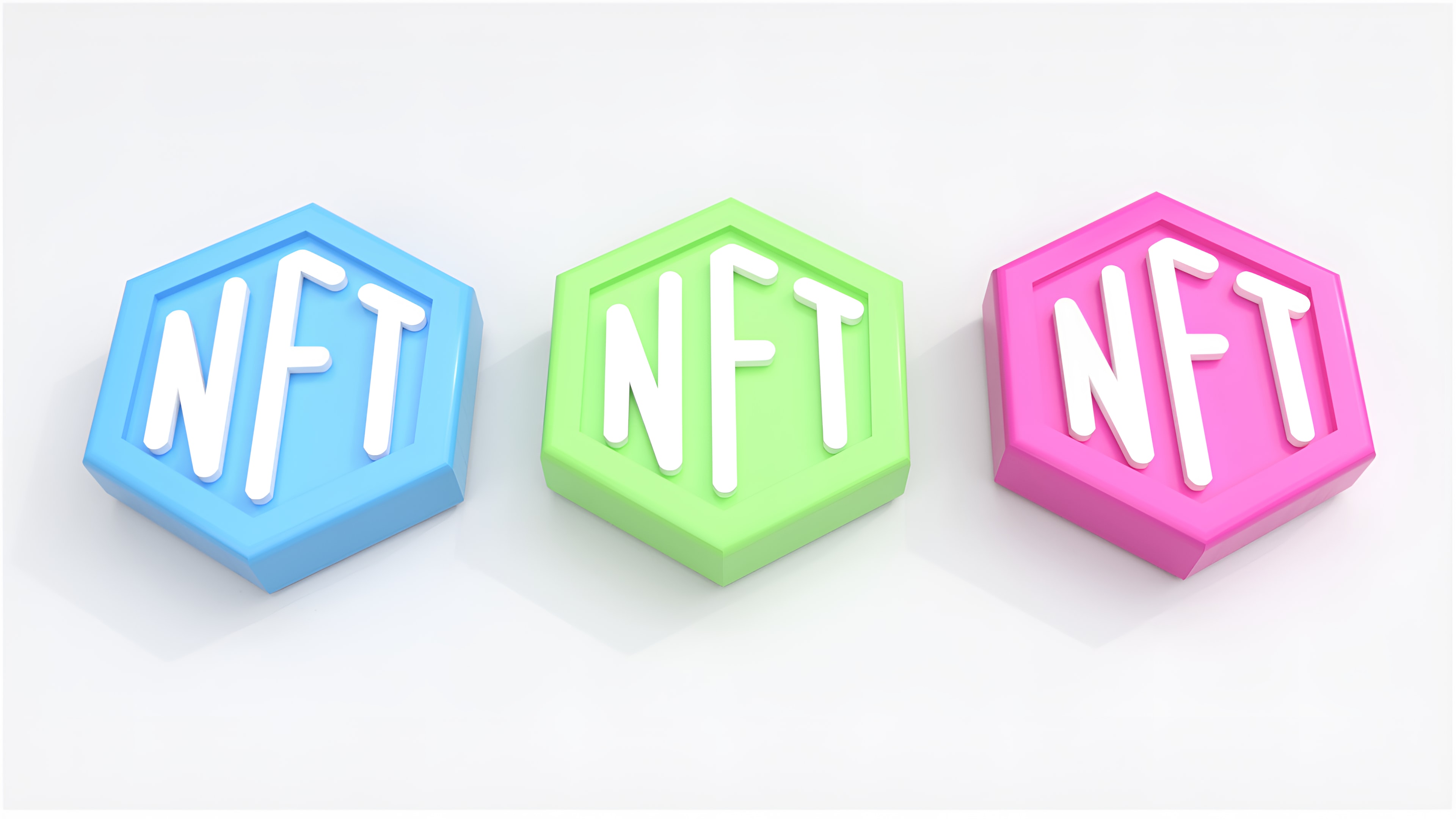 A plain white background with three hexagonal buttons or candies, Blue, Light Green and Pink in colour from left to right. NFT is written on them in white block letters. Picture by Choong Deng Xiang on Unsplash.